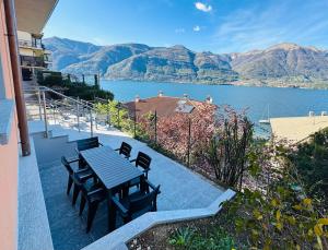 d'une table et de chaises sur un balcon avec vue sur le lac. dans l'établissement Appartamento Sosta sul Lago, à Lezzeno