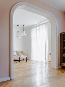 einen Torbogen in einem weißen Zimmer mit einem Tisch in der Unterkunft HORAMI Villa - ORIGAMI Apartment mit Terrasse in Malchow