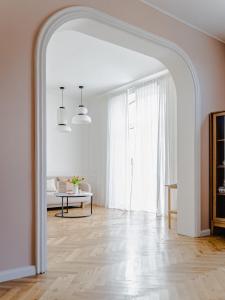 an archway in a white room with a table at HORAMI Villa - ORIGAMI Apartment mit Terrasse in Malchow