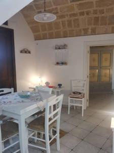a white dining room with a white table and chairs at Casa Centro storico Gallipoli in Gallipoli
