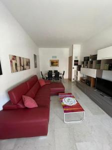 uma sala de estar com um sofá vermelho e uma mesa em Splendido appartamento in zona fiera a bologna em Bolonha