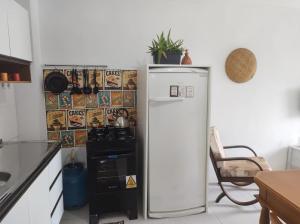 a white refrigerator in a kitchen next to a stove at Morada Héstia in Imbé