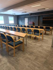 une salle de conférence avec des tables et des chaises en bois dans l'établissement Verdde Hotel Lakselv, à Lakselv