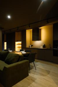 een keuken en een woonkamer met een bank en een tafel bij Luxury Apartments-Belochka in Oezjhorod