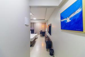 a room with a bed and a painting on the wall at Garvey Park Hotel - apartamento particular 629 in Brasilia