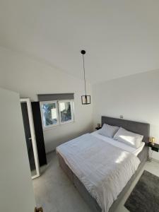 1 dormitorio con 1 cama grande y 2 ventanas en Mala Smokva en Vir