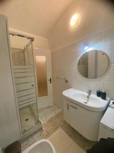 a bathroom with a sink and a toilet and a mirror at Casa Roma in Collegno