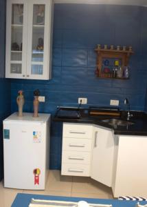 a kitchen with a sink and a refrigerator at Espaço Azul in Curitiba