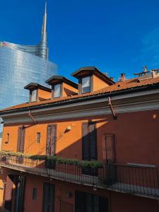 Avdkapartment في ميلانو: مبنى برتقالي مع شرفة أمام ناطحة سحاب