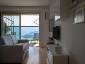 ein Wohnzimmer mit einem Sofa und einem TV in der Unterkunft Segesta - with panoramic outdoor area and swimming pool in Parzanica
