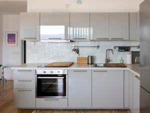 a white kitchen with white cabinets and a sink at Segesta - with panoramic outdoor area and swimming pool in Parzanica