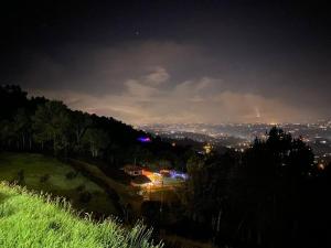 a house on top of a hill at night at El Mirador de LucyMelia in Guarne
