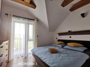 1 dormitorio con cama y ventana grande en Holiday Home Kamienok 2 en Liptovský Mikuláš