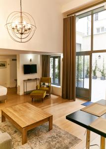 - un salon avec un canapé et une table dans l'établissement Apartments Du Louvre - Le Marais, à Paris