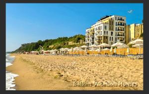 a sandy beach with umbrellas and a hotel at Diamond Beach Luxus Apart 22 Obzor in Obzor