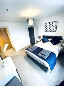 a bedroom with a large bed with a blue blanket at 1 Bedroom flat in Peterborough City centre in Peterborough