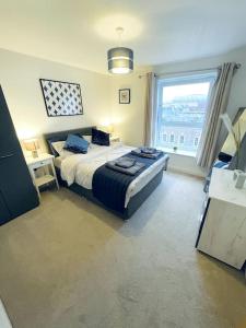 1 Bedroom flat in Peterborough City centre في بيتيربورو: غرفة نوم بسرير ونافذة كبيرة