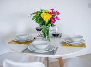 a white table with a vase of flowers on it at 1 Bedroom flat in Peterborough City centre in Peterborough