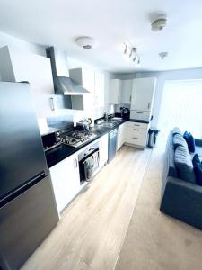 a kitchen with a stove and a couch in a room at 1 Bedroom flat in Peterborough City centre in Peterborough
