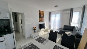 a living room with a couch and a television at Diamond Beach Luxus Apart 22 Obzor in Obzor