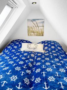a bedroom with a bed with a blue comforter at Tiny House Schwienhuck in Holtgast