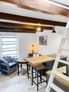 Habitación con una mesa de madera y una escalera. en Tiny House Schwienhuck en Holtgast