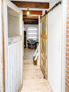an open door into a hallway with a brick wall at Tiny House Schwienhuck in Holtgast