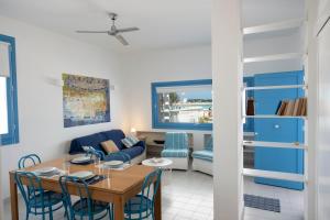 a dining room and living room with a table and chairs at Casa Azzurra sul mare e centralissima in San Vito lo Capo