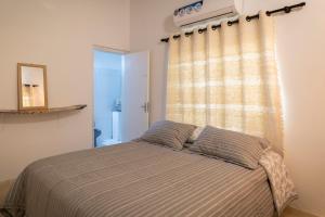 ein Bett mit zwei Kissen in einem Schlafzimmer mit einem Fenster in der Unterkunft La Maria Casa Campo in Paraguarí