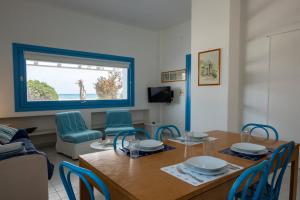 a living room with a table and blue chairs at Casa Azzurra sul mare e centralissima in San Vito lo Capo