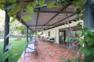 eine Terrasse mit Bänken und Tischen auf einem Haus in der Unterkunft La Maria Casa Campo in Paraguarí