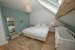 um quarto com uma cama branca e uma banheira em Le clos des voisins em Verneuil