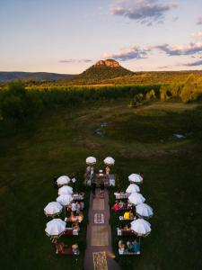 een groep tafels met paraplu's in een veld bij La Maria Casa Campo in Paraguarí