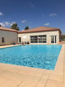 une grande piscine bleue devant une maison dans l'établissement Bienvenue chez Stéphane et Marina, à Gallargues-le-Montueux