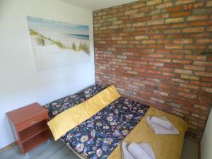 a room with two beds against a brick wall at Siedlisko PoMaLeńku in Żarnowska