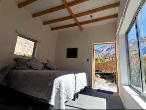 1 dormitorio con cama y ventana grande en Reset Elqui, en Alcoguaz