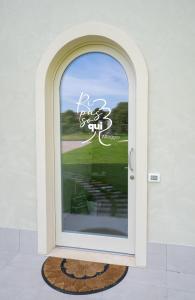 une porte donnant sur un panneau indiquant le parcours de golf sur une fenêtre dans l'établissement RipassoQui, à Custoza