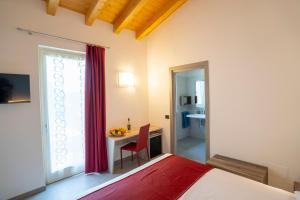 - une chambre avec un lit, un bureau et une fenêtre dans l'établissement RipassoQui, à Custoza