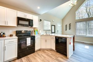 a kitchen with white cabinets and black appliances at Pocono Lake Vacation Rental Community Amenities! in Pocono Lake