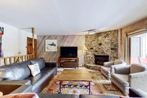 a living room with a couch and a stone fireplace at Phoenix 209 in Steamboat Springs