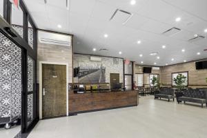 an office lobby with a reception desk and chairs at Highbridge Hotel in Bronx