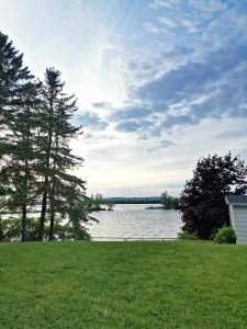 a view of a lake with trees and a house at Motel Sainte Catherine in Sainte-Catherine