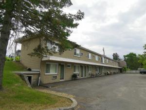 a building with a parking lot in front of it at Motel Sainte Catherine in Sainte-Catherine