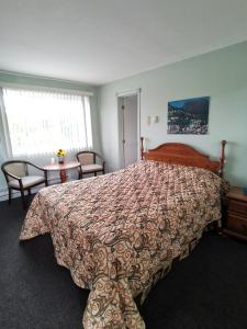 een slaapkamer met een bed en een tafel met stoelen bij Motel Sainte Catherine in Sainte-Catherine