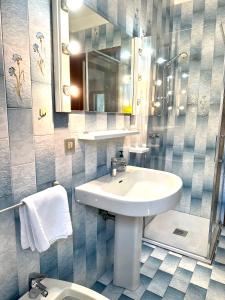 bagno con lavandino, specchio e servizi igienici di Villa Riviera by the Sea a Lignano Sabbiadoro