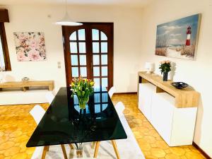 un soggiorno con tavolo in vetro con fiori di Villa Riviera by the Sea a Lignano Sabbiadoro