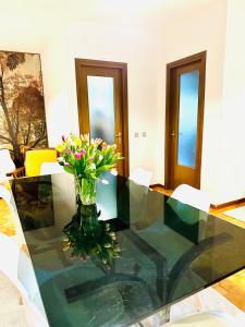 a glass table with a vase of flowers on it at Villa Riviera by the Sea in Lignano Sabbiadoro