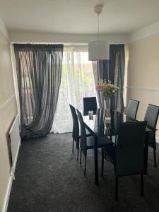 comedor con mesa, sillas y ventana en Stunning 3 bedroom property- Large Rooms, en Londres