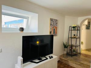 uma sala de estar com uma grande televisão de ecrã plano em Lagoa House - Casa típica Algarvia em Lagoa