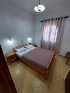 a bedroom with a large bed and a window at Anthy Villas department 1 in Mardhátion